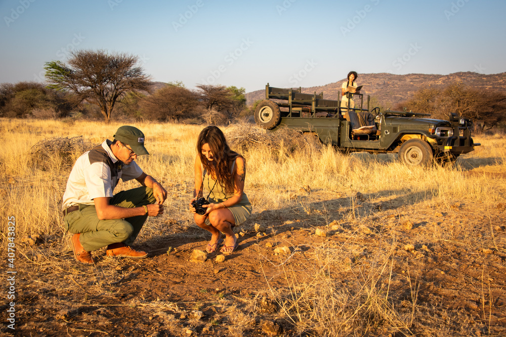 Obraz premium Guide explains something to brunette by jeep