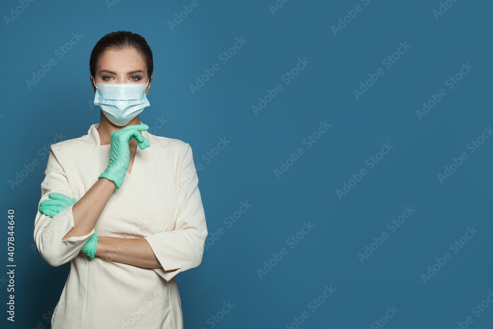 Doctor in protective medical mask and nitrile surgical gloves on blue background, medicine, safety and virus protection concept Doctor in protective medical mask and nitrile surgical gloves on blue background, medicine, safety and virus protection concept