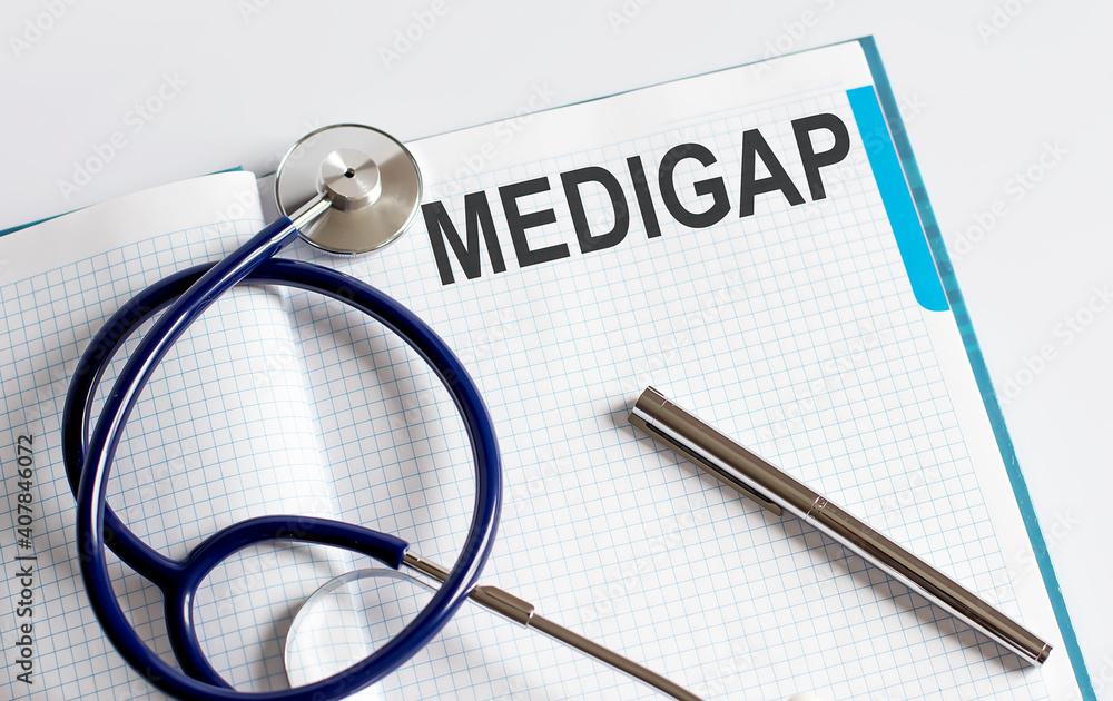 Paper with text MEDIGAP on table with stethoscope Paper with text MEDIGAP on table with stethoscope
