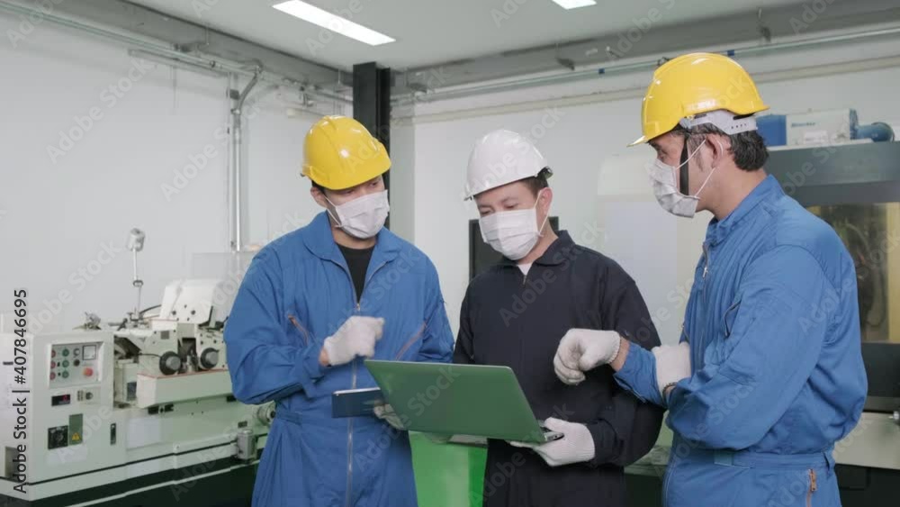 Asian engineer is explaining the workflow to factory workers. worker or engineer wearing disposal face mask for protect dust smoke and corona virus while working in factory. industrial concept. Asian engineer is explaining the workflow to factory workers. worker or engineer wearing disposal face mask for protect dust smoke and corona virus while working in factory. industrial concept.