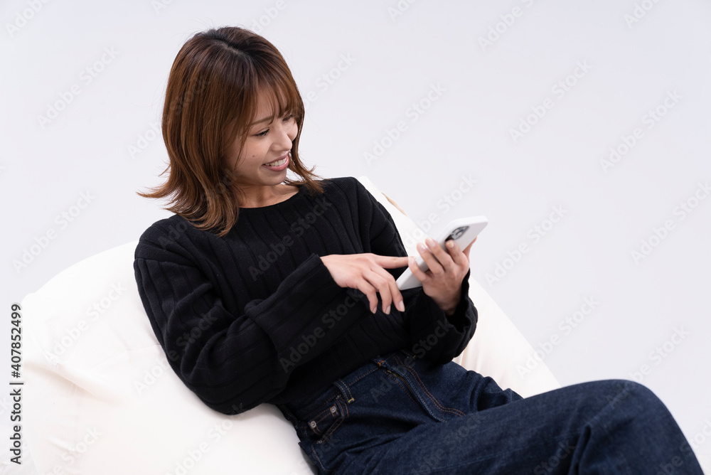 Naklejka premium リラックスしてスマートフォンを使う女性