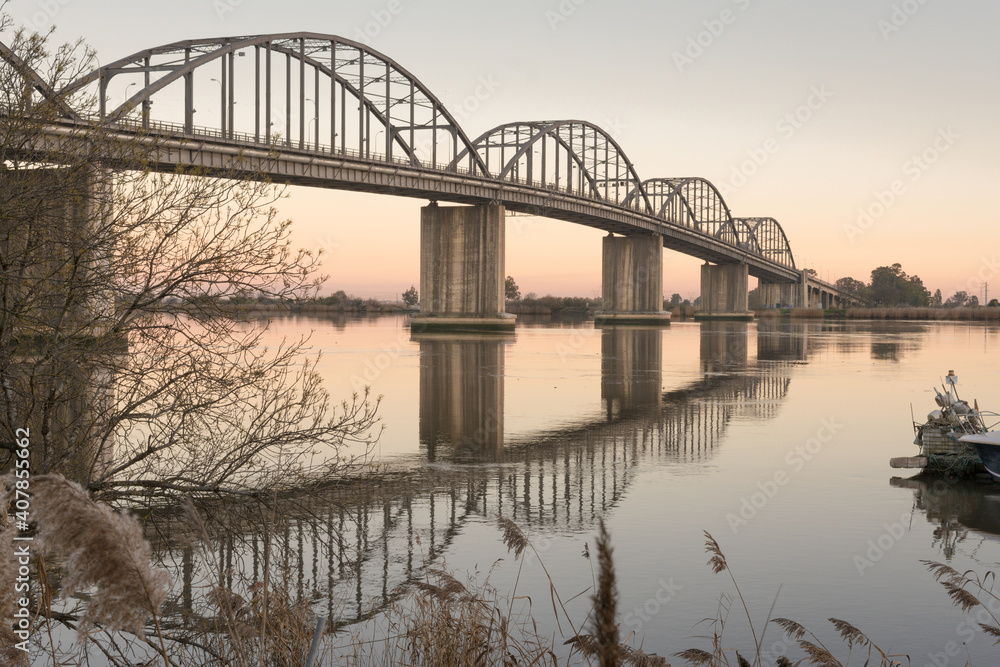 Obraz premium Old bridge over the river with reflections on the water, Marechal Carmona, Vila Franca Xira
