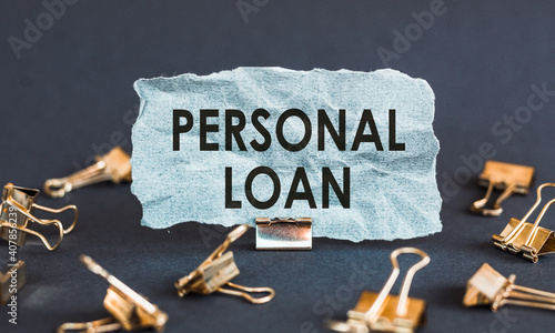 A scrap of blue paper with clips on a gray background with the text - PERSONAL LOAN.