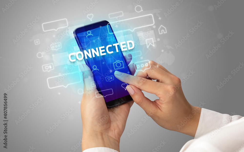 Female hand typing on smartphone with CONNECTED inscription, social media concept Female hand typing on smartphone with CONNECTED inscription, social media concept