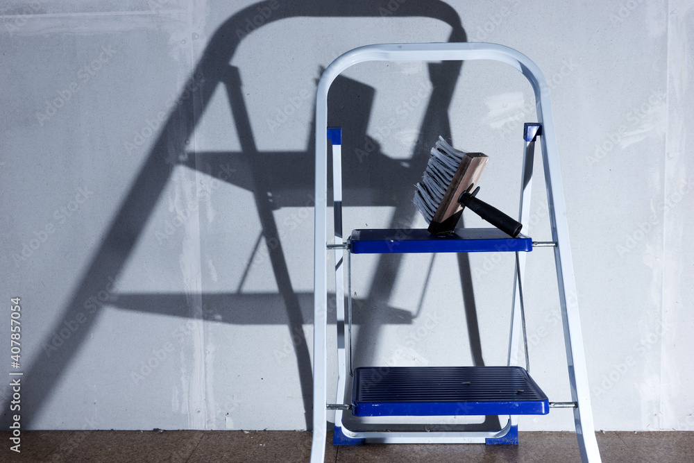 Naklejka premium Metal ladder with paintbrush standing in the empty room to renovate