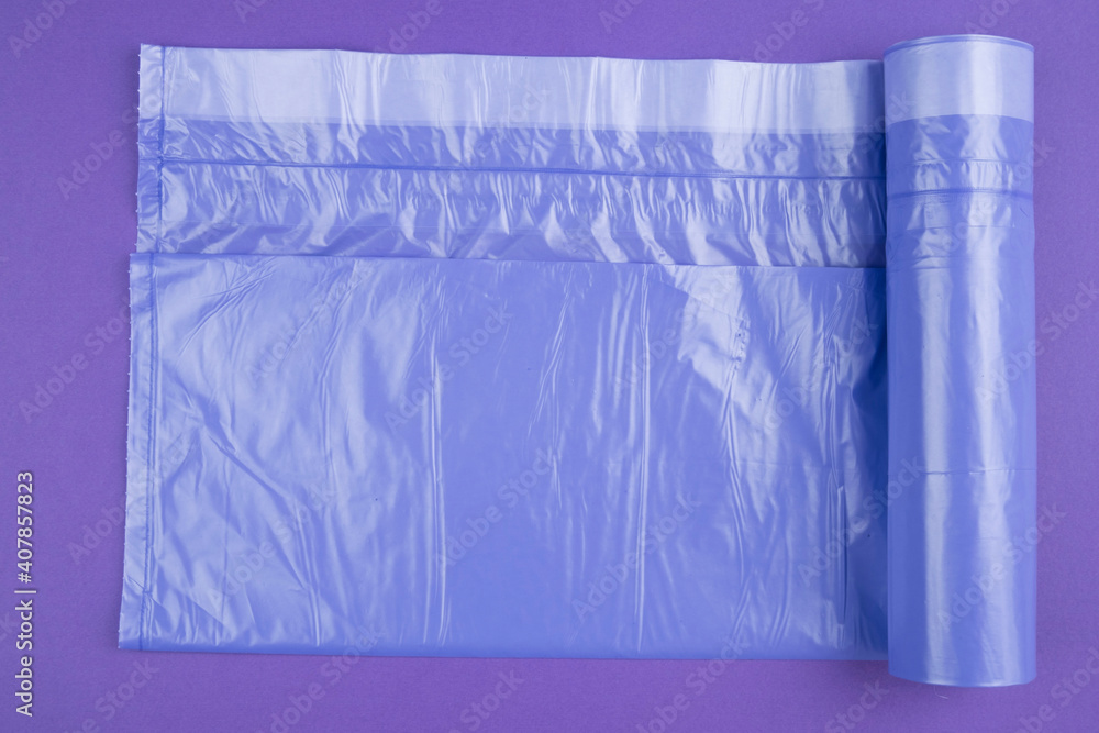 neatly folded purple garbage bags on a purple background. Place for the ad label.. Top view. Close-up