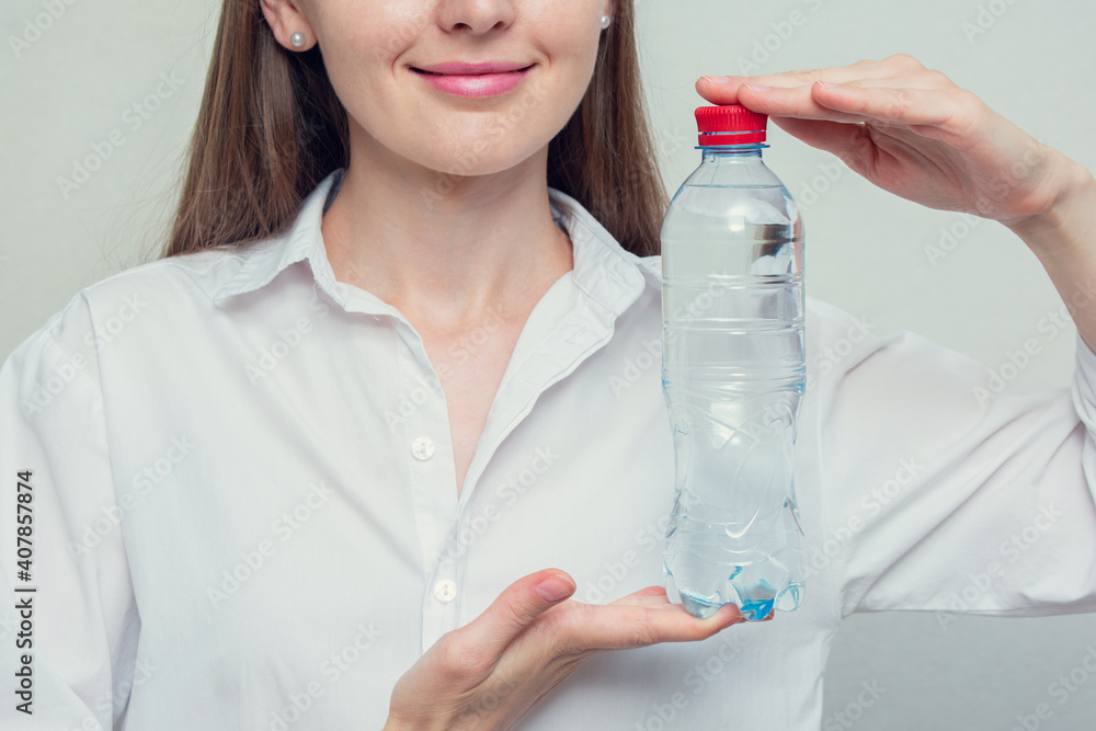 Young girl with bottle of drinking water, concept of drinking water, cropped image, closeup Young girl with bottle of drinking water, concept of drinking water, cropped image, closeup