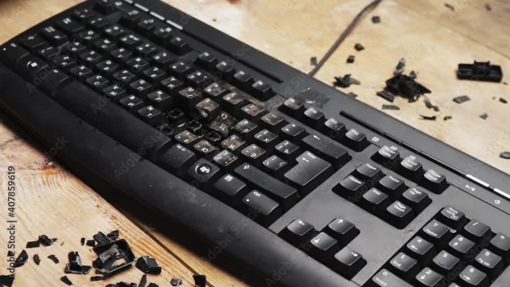 Shattered desktop keyboard. Lockdown. A fired worker smashes a computer ...