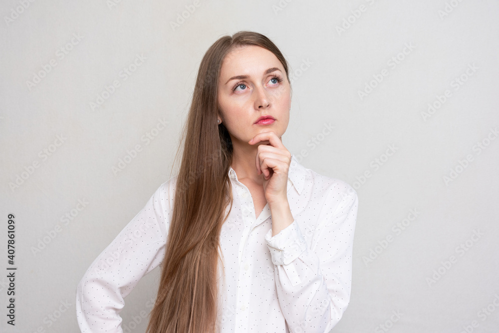 Thinking young girl standing isolated over white background, looking aside, copy space Thinking young girl standing isolated over white background, looking aside, copy space