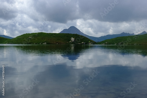 reflection from the mountains and clouds in a mountain lake