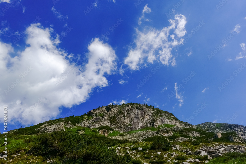soft white clouds on a blue sky while hiking in the mountains