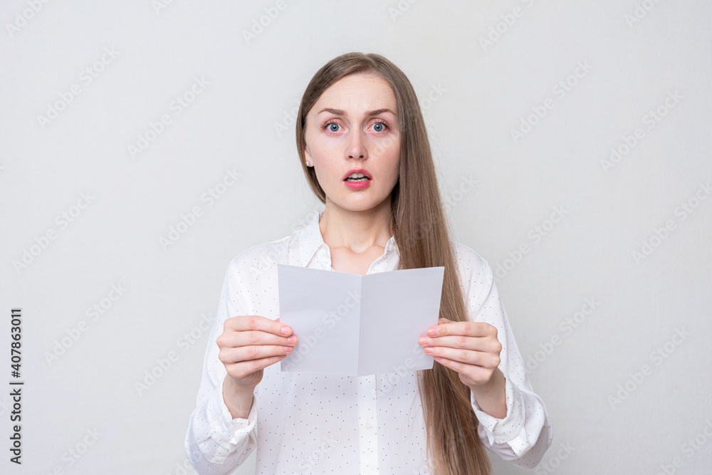 Portrait of a shocked woman reading a letter, white background Portrait of a shocked woman reading a letter, white background