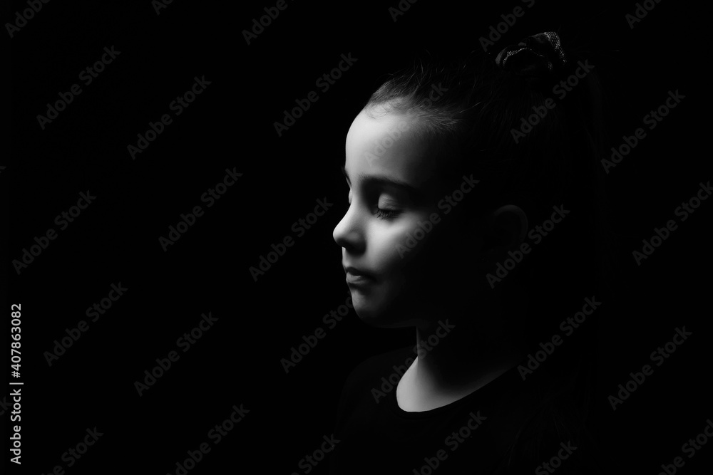 Closeup portrait of happy little girl isolated on black background