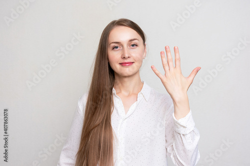 Wallpaper Mural Young woman shows five fingers, portrait, white background Torontodigital.ca