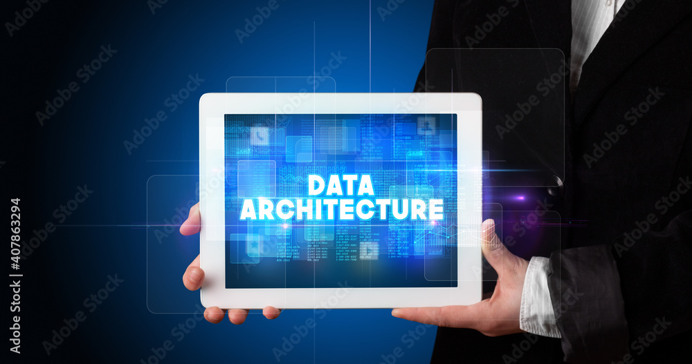 Young business person working on tablet and shows the inscription: DATA ARCHITECTURE Young business person working on tablet and shows the inscription: DATA ARCHITECTURE