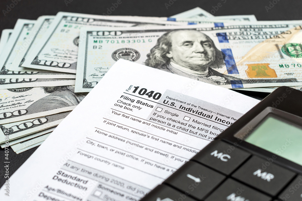 Obraz premium Tax form with calculator and money on black.