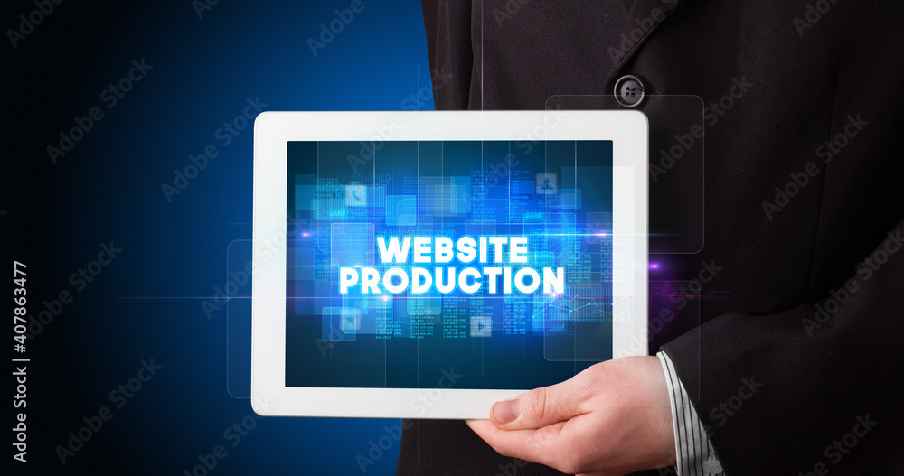Young business person working on tablet and shows the inscription: WEBSITE PRODUCTION