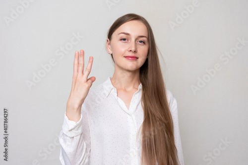 Wallpaper Mural Young woman shows four fingers, portrait, white background Torontodigital.ca