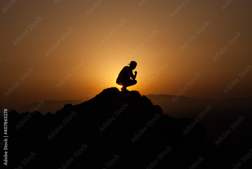 silhouette of a man watching the sunset