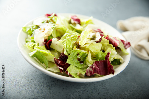 Healthy mixed green salad in a white bowl