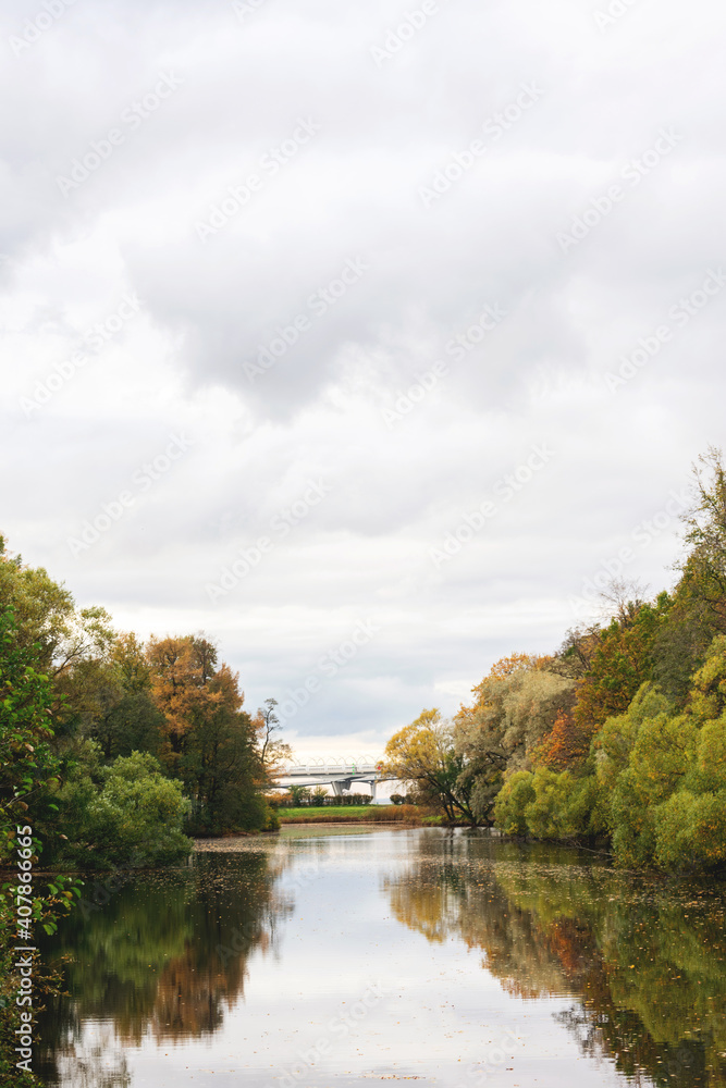 Autumn landscape with reflection in the lake, fluffy clouds, vertical, Saint Petersburg, Kirov Central Park of culture and recreation