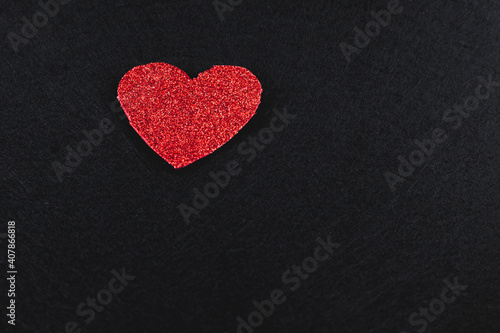 Red glitter heart on black background