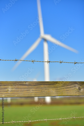 Blurry large windmill against the blue sky.