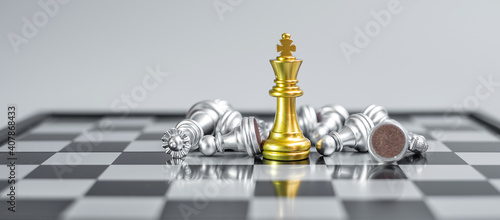 gold Chess King figure stand out from crowd of enermy or opponent during chessboard competition. Strategy, Success, management, business planning, interruption, win and leadership concept photo