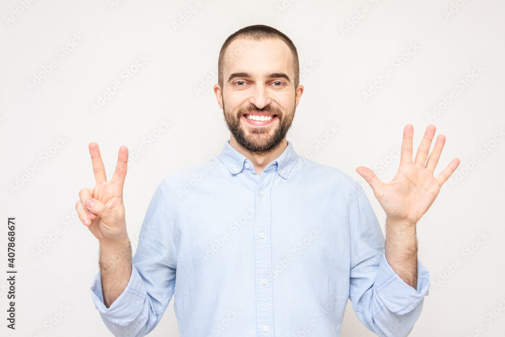 Bearded man shows fingers seven, white background, copy space