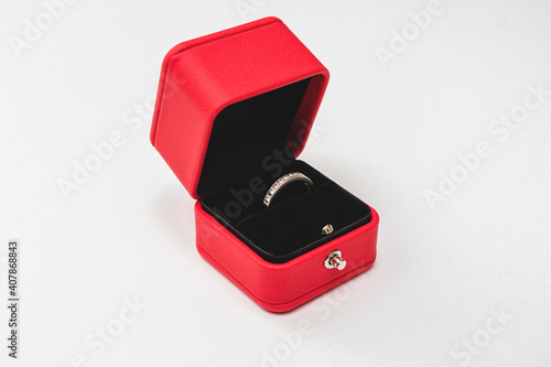 Wedding ring in red box, white background, side view, copy space