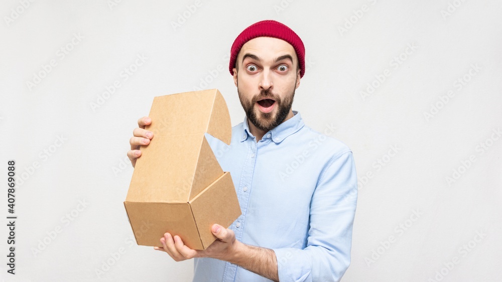 Amazed bearded man opens a box, portrait, white background, copy space Amazed bearded man opens a box, portrait, white background, copy space