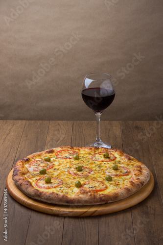 ricardo fernando franca junior pizza mussarela muçarela mucarelMozzarella cheese pizza with red tomato slices. A glass of red wine on the right to accompany. Vertical photography.