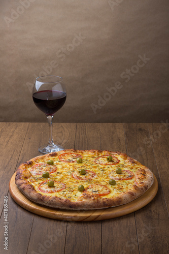 ricardo fernando franca junior pizza mussarela muçarela mucarelMozzarella cheese pizza with red tomato slices. A glass of red wine on the left to accompany. Vertical photography