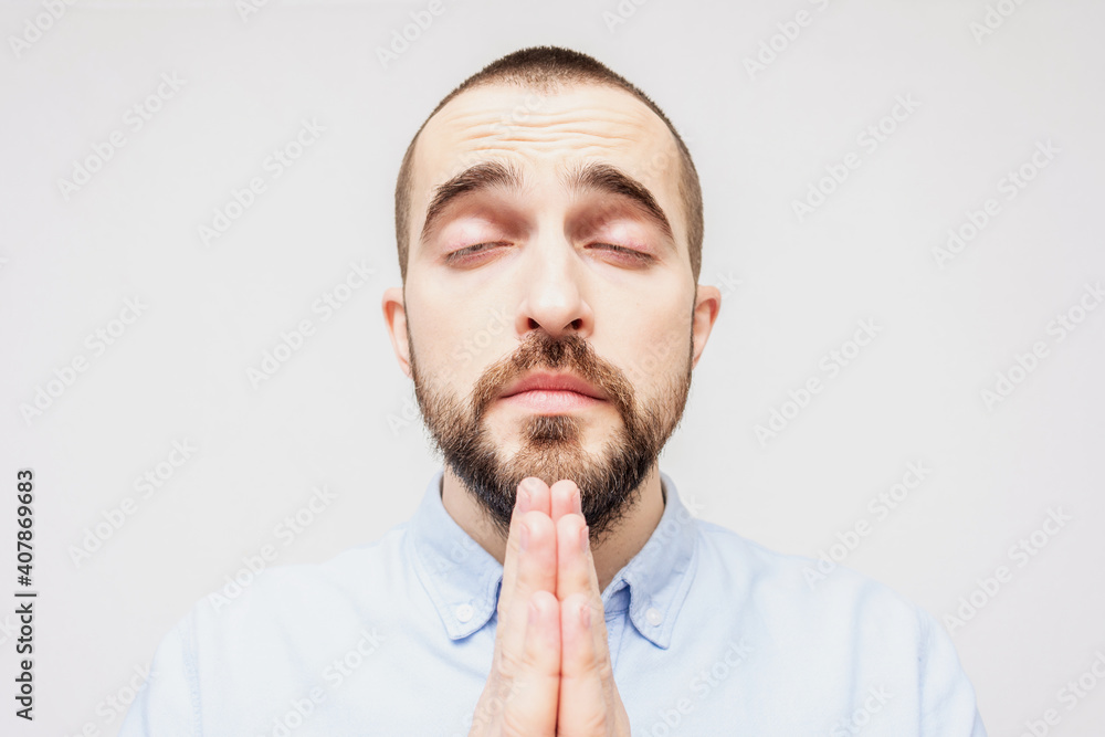 Serene religious bearded man prays, man folded his hands in prayer, portrait, closeup Serene religious bearded man prays, man folded his hands in prayer, portrait, closeup