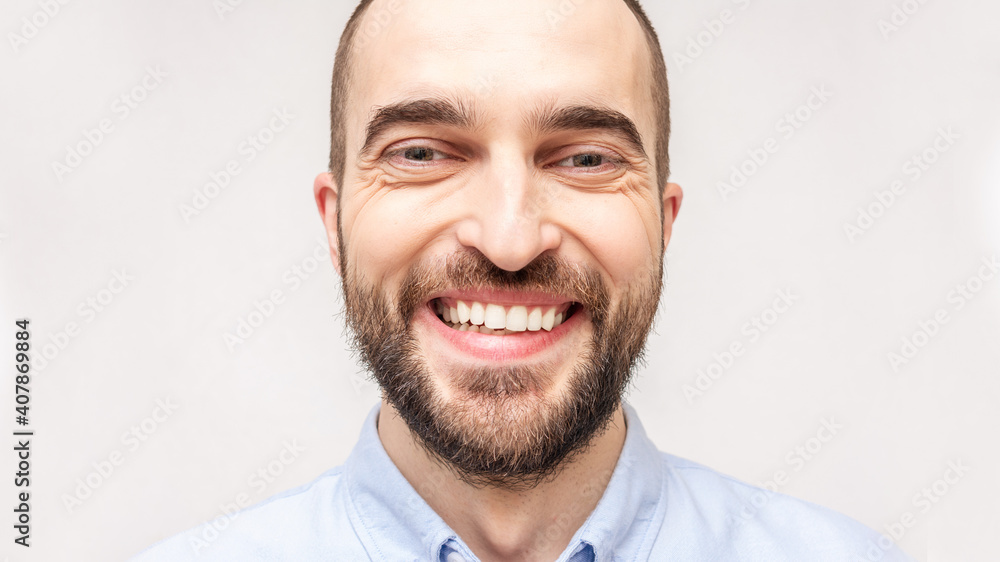Fototapeta premium Laughing bearded man smiling and looking in the camera, portrait, close up, toned, 16:9, copy space
