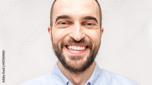 Laughing bearded man smiling and looking in the camera, portrait, close up, toned, 16:9, copy space