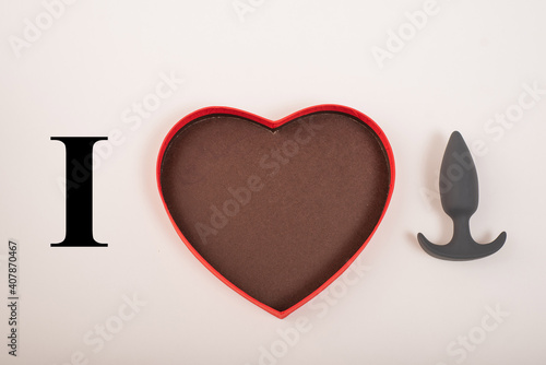 Heart-shaped box and butt plug on a white background. Love on February 14.