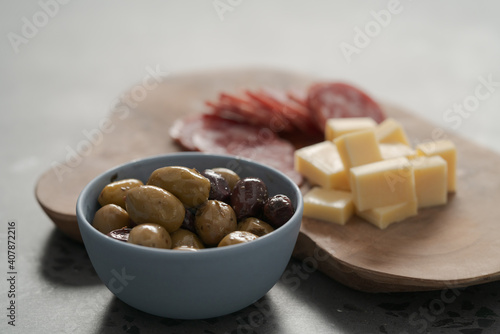 olives, salami and vintage cheese on concrete countertop photo