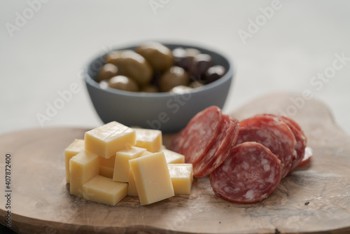 olives, salami and vintage cheese on concrete countertop photo