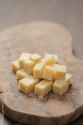 Pieces of hard vintage cheese on wood olive board