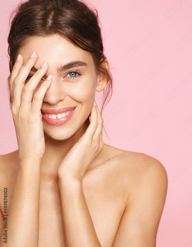 Beauty and skincare. Vertical portrait of young naked woman with white smile, touching healthy nourished skin, use cosmetics for skint tone balance and anti-aging effect, pink background Beauty and skincare. Vertical portrait of young naked woman with white smile, touching healthy nourished skin, use cosmetics for skint tone balance and anti-aging effect, pink background