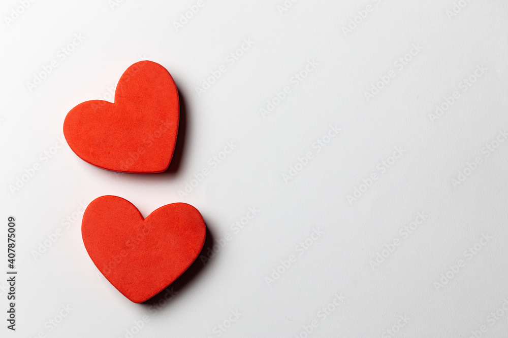 2 Red heart shapes over white paper background