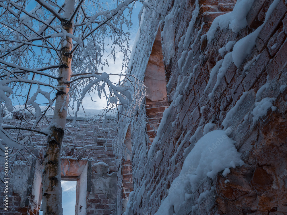 An old ruined brick building with empty windows. Instead of a roof there is a blue evening sky with clouds. A tree grew inside. An old ruined brick building with empty windows. Instead of a roof there is a blue evening sky with clouds. A tree grew inside.