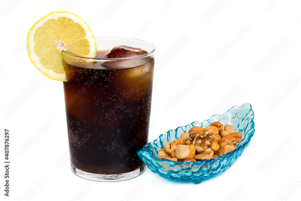 Refresco de cola con una rodaja de limón acompañado por aperitivos de frutos secos Refresco de cola con una rodaja de limón acompañado por aperitivos de frutos secos