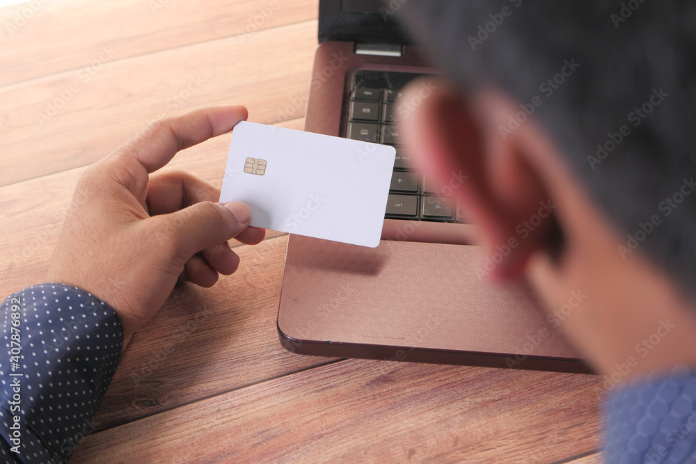 man hands holding credit card and using laptop shopping online man hands holding credit card and using laptop shopping online