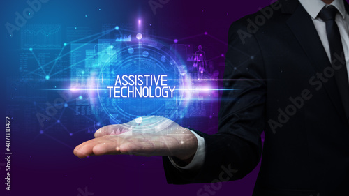 Man hand holding ASSISTIVE TECHNOLOGY inscription, technology concept