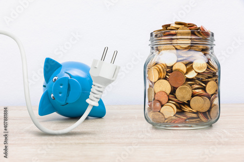 Sparschwein mit Stromstecker und Münzen