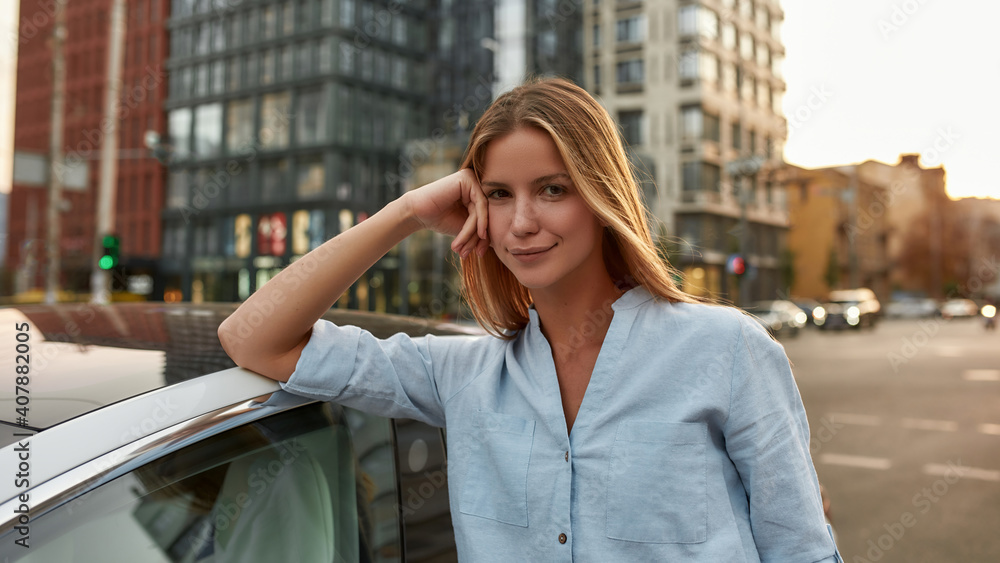 Portrait of smiling young caucasian girl leaning on car roof Portrait of smiling young caucasian girl leaning on car roof