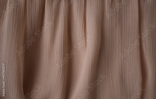 The texture of a luxurious beige chiffon fabric for a celebration, advertising poster, ceremony or invitation card, background
