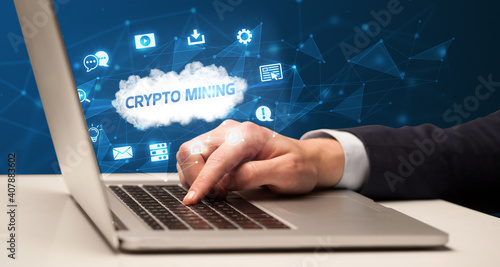 Businessman working on laptop with CRYPTO MINING inscription, modern technology concept
